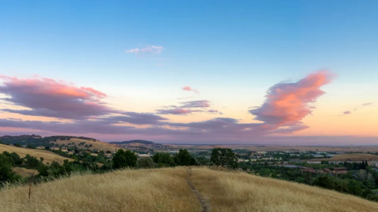 El Dorado Hills Sacramento area brown hills green trees pink clouds blue skies at sunset