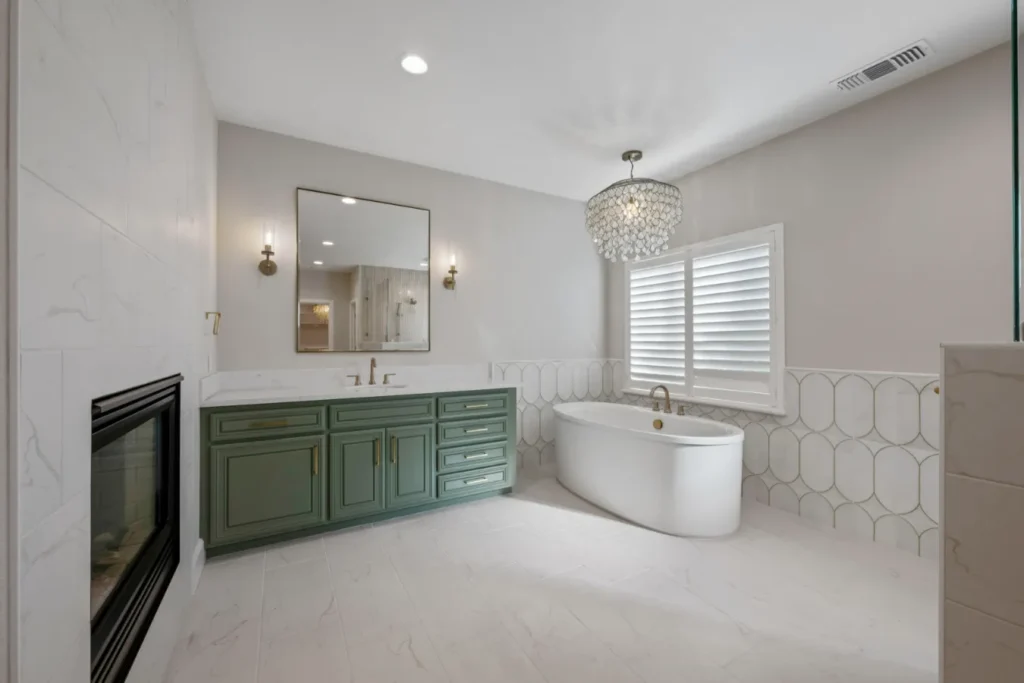 Interior of remodeled luxury bathroom, with minimalistic color palette and decor, featuring green sink vanity.